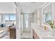 Bright bathroom with glass shower, stone flooring, backlit mirror, and wooden vanity at 4822 Ocean Blvd # 8C, Sarasota, FL 34242