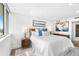Bright bedroom featuring large window, sleek white walls, art pieces, and matching nightstands at 4822 Ocean Blvd # 8C, Sarasota, FL 34242