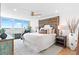 Bright bedroom featuring a large window, wood floors, and intricately carved wood headboard at 4822 Ocean Blvd # 8C, Sarasota, FL 34242