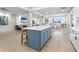 Open-concept lounge area with a large kitchen island, bar stools, and tiled floors at 4822 Ocean Blvd # 8C, Sarasota, FL 34242