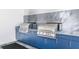Outdoor kitchen area featuring two stainless steel barbeque grills and blue cabinetry at 4822 Ocean Blvd # 8C, Sarasota, FL 34242