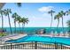 Community pool with lounge chairs, beautiful landscaping, and ocean views at 4822 Ocean Blvd # 8C, Sarasota, FL 34242