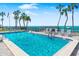 Sparkling swimming pool with palm trees, lounge chairs, and ocean views at 4822 Ocean Blvd # 8C, Sarasota, FL 34242