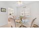 Bright dining area with glass table and four chairs, kitchen view at 521 W Venice Ave # 22, Venice, FL 34285