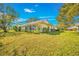 Backyard view showing a home with a large grassy area at 5803 Garden Lakes Palm, Bradenton, FL 34203