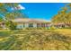 Home's backyard with a large green lawn and trees at 5803 Garden Lakes Palm, Bradenton, FL 34203