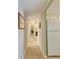 Long hallway with carpet, neutral walls, and bathroom access at 5938 Welcome Rd # H22, Bradenton, FL 34207