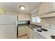 Efficient kitchen with stove, sink, and cabinets at 5938 Welcome Rd # H22, Bradenton, FL 34207