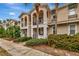 Tan townhouses with balconies, lush landscaping, and palm trees at 5972 Giardino Ln, Sarasota, FL 34232