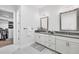 Elegant bathroom with double vanity, dark countertops, and access to a closet at 6404 Pigeon Plum Way, Bradenton, FL 34210