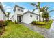 White modern house with palm trees and a landscaped yard at 6404 Pigeon Plum Way, Bradenton, FL 34210