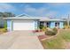 Light blue house with white garage door, American flag, and landscaped yard at 6605 63Rd E Ave, Palmetto, FL 34221