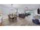 Open living room with grey sectional sofa, hardwood floors, and view of patio at 6650 Cheswick St, Sarasota, FL 34243