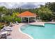 Community pool with adjacent cabana, lounge chairs, and tables at 6650 Cheswick St, Sarasota, FL 34243