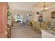 Open concept living and dining area with beige sofas, glass-top dining table, and view to backyard at 676 Planters Manor Way, Bradenton, FL 34212