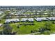 Aerial view of a community of single story homes with a large green lawn at 6810 9Th W Ave, Bradenton, FL 34209
