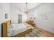 Bright bedroom with wood floors, a mustard yellow bed, and plantation shutters at 689 Lands End Dr, Longboat Key, FL 34228