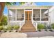 Charming front porch with wooden stairs and screened-in area at 689 Lands End Dr, Longboat Key, FL 34228