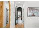 Bright hallway with wood floors, arched doorway to bedroom, and stylish mirror at 689 Lands End Dr, Longboat Key, FL 34228