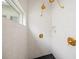 Modern shower with star patterned tile, gold fixtures, and a small window at 689 Lands End Dr, Longboat Key, FL 34228