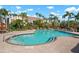 Community pool with brick paved deck surrounded by lounge chairs and tables at 7484 Botanica Pkwy # 101 B-24, Sarasota, FL 34238