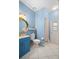 Blue bathroom with vanity, toilet, and shower at 7737 40Th E Ct, Sarasota, FL 34243