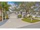 Two-story house with a gray exterior, paved driveway, and landscaping at 7737 40Th E Ct, Sarasota, FL 34243