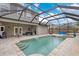 Inviting pool area with covered patio, outdoor seating, and lush landscaping at 7737 40Th E Ct, Sarasota, FL 34243