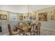 Elegant dining room featuring a wood table, six chairs, and a wall of artwork at 8115 Miramar Way # 202, Lakewood Ranch, FL 34202