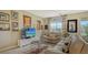 Spacious living room with light beige sofas, a glass coffee table, and large windows at 8115 Miramar Way # 202, Lakewood Ranch, FL 34202