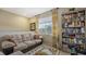 Cozy sitting area with beige sofa, bookcase, and window with natural light at 8115 Miramar Way # 202, Lakewood Ranch, FL 34202