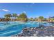 A large pool is surrounded by palm trees and lounge chairs on a sunny day, with a clear blue sky overhead at 9230 Isabella Cir, Parrish, FL 34219