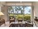 Relaxing sunroom with wicker furniture and serene golf course views at 9490 High Gate Dr # 2013, Sarasota, FL 34238