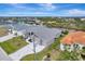 Aerial view of a canal-front home with a gray roof and paver driveway at 10442 Winnipeg St, Port Charlotte, FL 33981