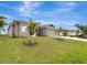 Exterior view of house with lush lawn and palm trees at 10442 Winnipeg St, Port Charlotte, FL 33981