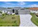 Two-story house with gray exterior, paver driveway, and landscaping at 10442 Winnipeg St, Port Charlotte, FL 33981