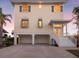 Two-story house with light-yellow siding, white trim, and a three-car garage at 114 Gull Dr, Anna Maria, FL 34216