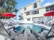 Private pool with lounge chairs and red umbrellas at 114 Gull Dr, Anna Maria, FL 34216