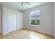 Bright bedroom with wood floors and double door closet at 11662 Old Cypress Cv, Parrish, FL 34219