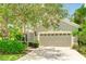 Tan house with two-car garage and lush landscaping at 11662 Old Cypress Cv, Parrish, FL 34219