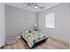 Cozy bedroom with dinosaur bedding and light grey walls at 11813 Holly Hock Dr, Lakewood Ranch, FL 34202