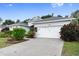 House exterior featuring a white garage door and well-manicured landscaping at 11813 Holly Hock Dr, Lakewood Ranch, FL 34202