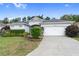 House exterior with a white garage door, landscaping, and a paved driveway at 11813 Holly Hock Dr, Lakewood Ranch, FL 34202