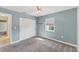 Bedroom features a closet, window, neutral carpet, ceiling fan, and adjacent access to another room at 1219 Sleepy Hollow Rd, Venice, FL 34285