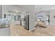Open kitchen with white cabinets, stainless steel appliances, and light wood flooring at 1219 Sleepy Hollow Rd, Venice, FL 34285