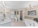 Luxury main bathroom featuring double sinks, soaking tub, and a glass-enclosed shower with tile surround at 1219 Sleepy Hollow Rd, Venice, FL 34285