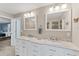 Main bathroom featuring a double vanity, great lighting, and entry to the glass enclosed shower at 1219 Sleepy Hollow Rd, Venice, FL 34285