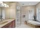 Bathroom with a large soaking tub, walk-in shower, and updated fixtures at 1227 Tuscany Blvd, Venice, FL 34292