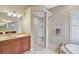 Elegant bathroom with a walk-in shower, soaking tub, and double vanity at 1227 Tuscany Blvd, Venice, FL 34292
