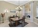 Elegant dining room with a rustic wooden table and chandelier at 1227 Tuscany Blvd, Venice, FL 34292